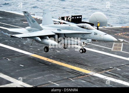 A US Navy F/A-18C Hornet fighter lands on the flight deck of the aircraft carrier USS Nimitz April 4, 2013 in the Pacific Ocean. Stock Photo