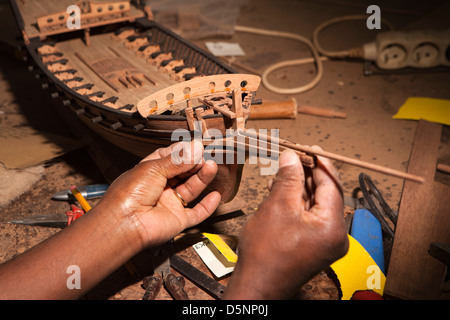 Madagascar, Antananarivo, Crafts, Le Village model boat making workshop, craftsman’s hands fitting bowsprit Stock Photo