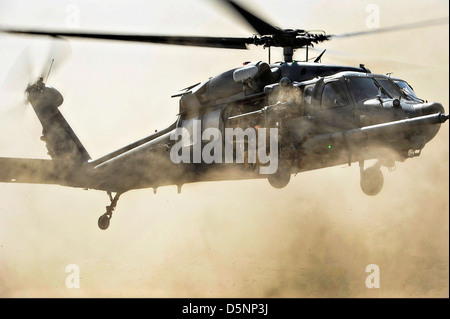 A US Air Force HH-60G Pave Hawk helicopter comes in for a fast landing to pick up pararescuemen during a combat search and rescue exercise March 23, 2013 in the Grand Bara Desert, Djibouti. Stock Photo