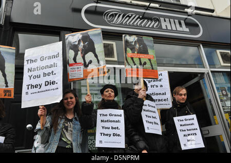 Victoria, London, UK. 6th April 2013. Demonstrators opposed to horse racing hold placards outside a betting shop before the Grand National race. Demonstration opposed to the Grand National race outside a William Hill betting shop. Credit: Matthew Chattle / Alamy Live News Stock Photo