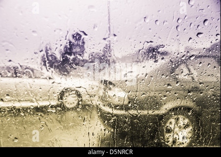 Raindrops on the car window while driving in rain Stock Photo