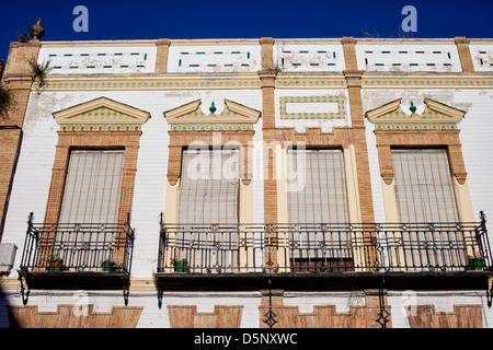 Traditional ornate facade of an Andalusian house with balconies and windows with outdoor roller blinds in Ronda, Spain. Stock Photo