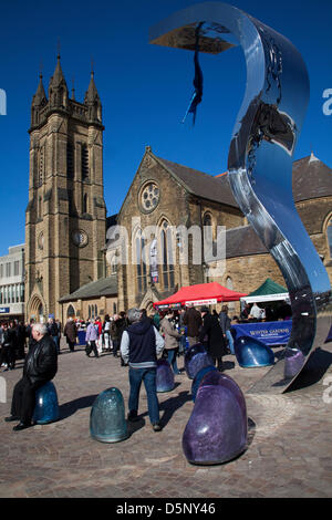 Wave statue artwork in Blackpool, Lancashire,UK Saturday April 6th 2013. Crowds at the 1st Great Blackpool Chilli Festival in the beautiful revamped St Johns Square, an landmark  event organised by Chilli Fest UK. Stock Photo