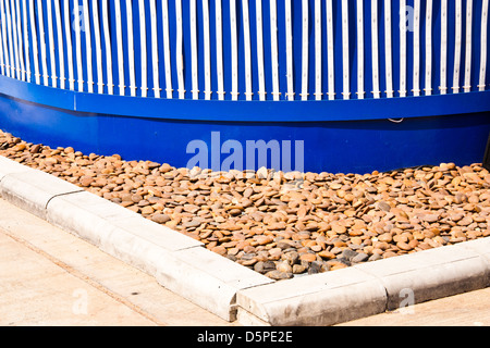 Building on the corner. The ground below the building is decorated with small stones. Stock Photo