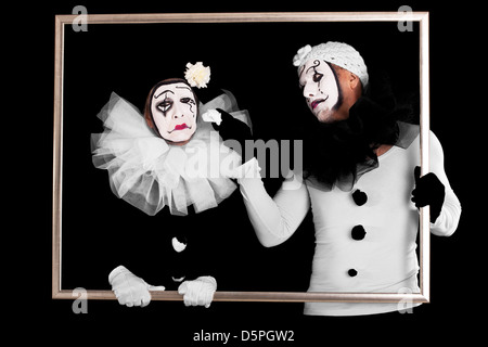 couple of clowns in a frame, one looks sorrowful Stock Photo