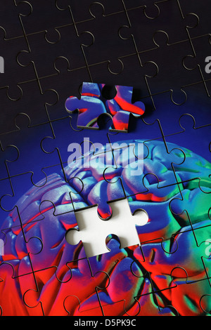 A piece missing from a jigsaw puzzle made from a photograph (with coloured flash) of a plastic model human brain. Stock Photo