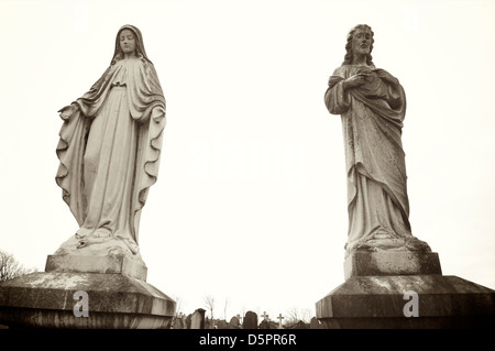 Statues of the virgin Mary and Christ on cemetery grave Stock Photo