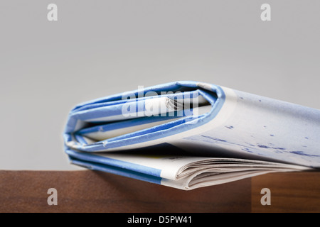 Folded newspapers on brown wooden table Stock Photo