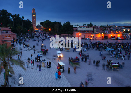 Djemaa el Fna, the main square in Marrakech, Morocco, at dusk, with the minaret of the Koutoubia Mosque in the background. Stock Photo