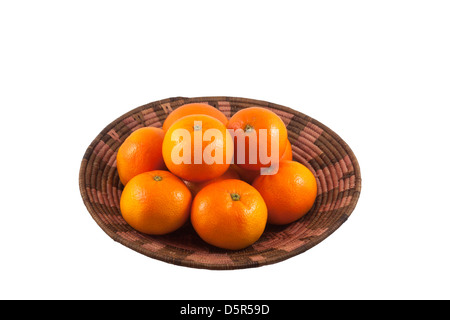 Organic mandarin oranges in African basket cutout on white background Stock Photo