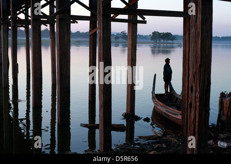 A young Burmese fisherman stands on the edge of his boat after a day on the lake. Stock Photo