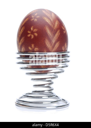 Soft-boiled egg with Easter ornament egg-shell in a spiral stand shot on white background Stock Photo