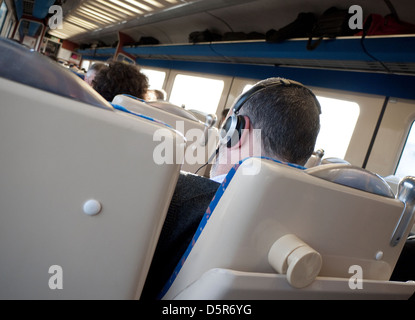 male passenger on train wearing headphones Stock Photo