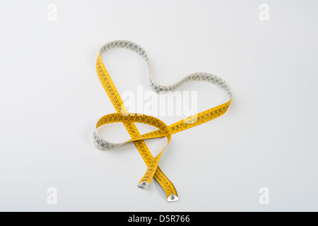 tape measure forming heart on white background Stock Photo