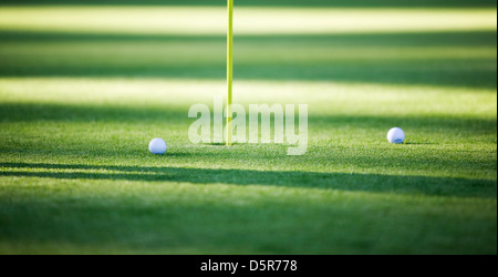 Two golf balls on putting green, focus on left side ball Stock Photo
