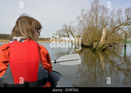 Young woman paddling a Sevylor Colorado Premium inflatable canoe at The Slaughters, Rockland Broad, Norfolk, Broads National Park Stock Photo