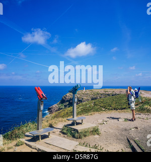 Coin binoculars and man carrying baby at Frehel cape Brittany France Stock Photo