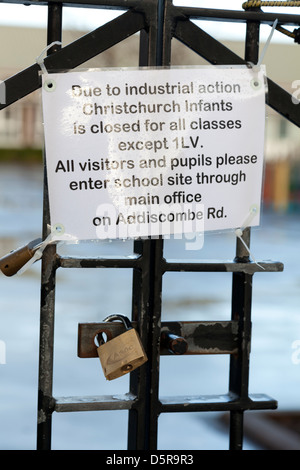 school closed due to industrial action sign on padlocked gates Stock Photo