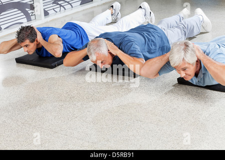 Elderly men doing back exercises in fitness center Stock Photo
