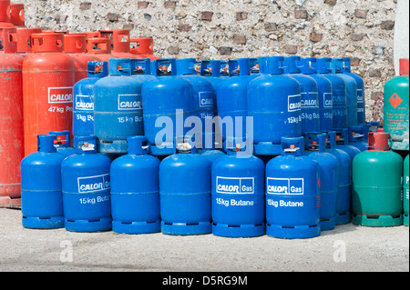 Stacks of red green and blue CALOR GAS butane and Propane cylinders / canisters / bottles Stock Photo