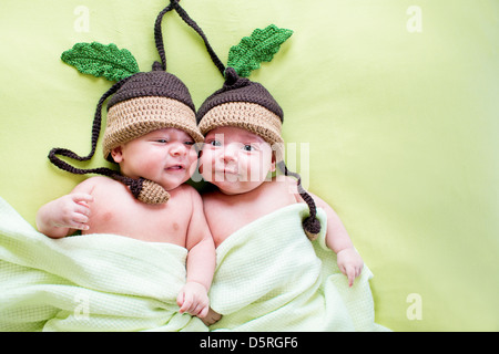 two twins brothers babies weared in acorn hats Stock Photo