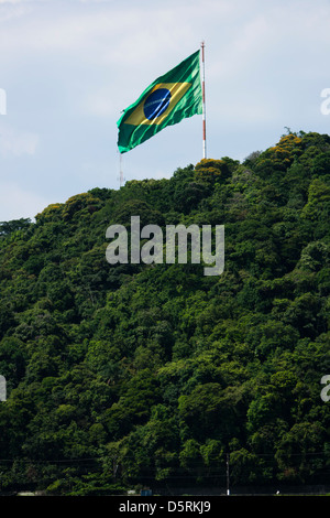 Brazil flag in the top of mountain in São Vicente city, São Paulo state shore.  strong wind Stock Photo