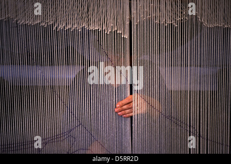 A weaver works on a carpet at the Gobelins Manufactory a historic tapestry factory in the 13th arrondissement of Paris France Stock Photo