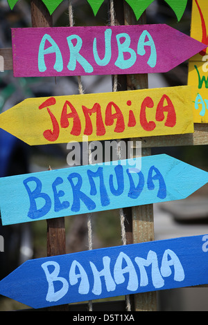 colorful signs pointing to various Caribbean tropical islands Stock Photo