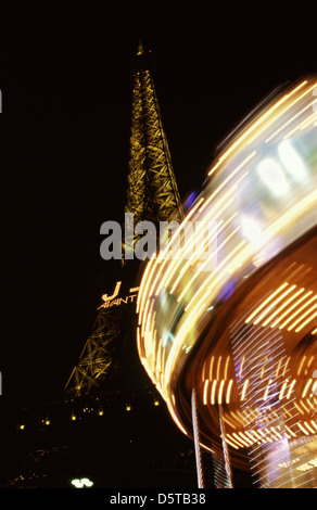 Carousel spinning around lit up at night with Eiffel tower in background Paris France Stock Photo