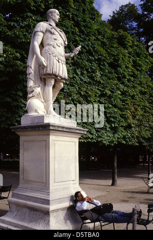 A man resting beneath the statue of Julius Caesar in Jardin des Tuileries garden in the 1st arrondissement of Paris France Stock Photo