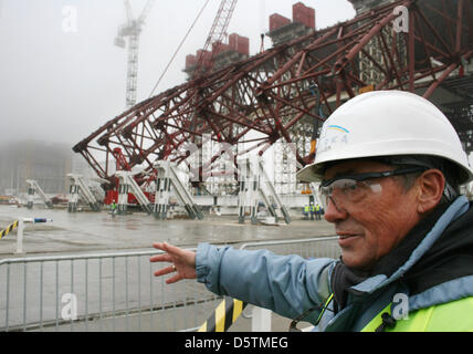 English chief of security of the constrcution site in Chernobyl, David Jackson, explains the constrcution of the new containment strcuture for the nuclear reactor (L in the fog) in Chernobyl, Ukraine, 27 November 2012. The Chernobyl disaster took place in 1986, the new containment structure is planned to be put into place at the end of 2015. Photo: WOLFGANG JUNG Stock Photo