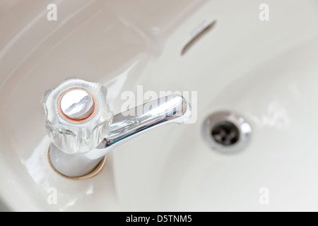 Hot tap and wash basin in a bathroom Stock Photo