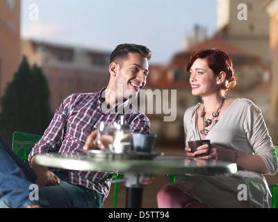 beautiful couple on coffee on the terrace in the town square at sunset Stock Photo