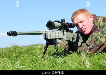 British infantry soldier is seen looking down the telescopic sight of the new British-made Long Range L115A3 sniper rifle Stock Photo