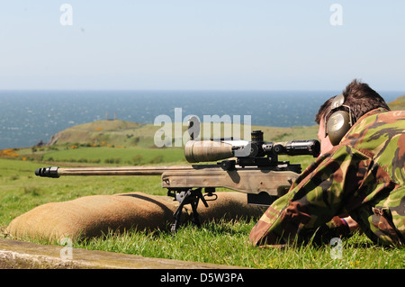 British infantry soldier is seen looking down the telescopic sight of the new British-made long range L115A3 sniper rifle Stock Photo