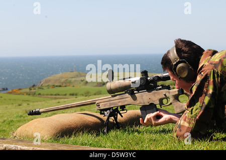 British infantry soldier is seen looking down the telescopic sight of the new British-made long range L115A3 sniper rifle Stock Photo