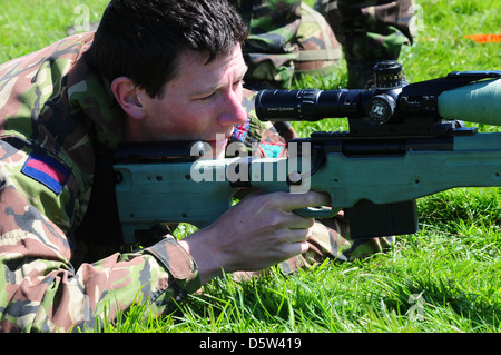 British infantry soldier is seen looking down the telescopic sight of the new British-made long range L115A3 sniper rifle Stock Photo