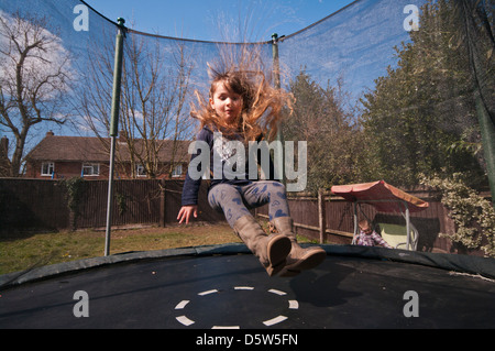 5 Year Old Child Jumping On A Garden Trampoline