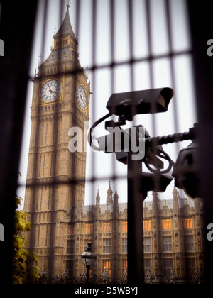 Security camera is monitoring the area behind the bars of the metal fence around Big Ben and The Houses Of Parliament Stock Photo