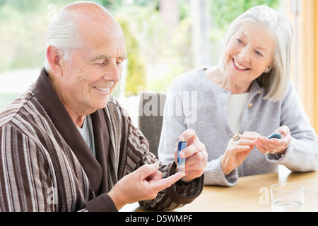 Older couple testing blood sugar together Stock Photo