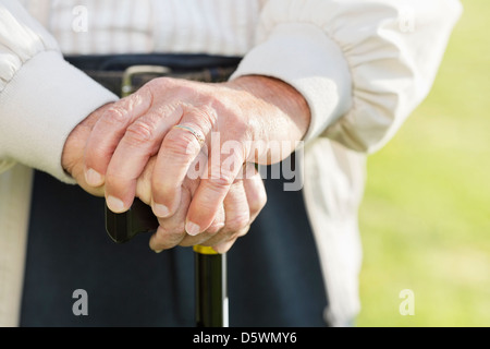 Close up of older man's hands on cane Stock Photo