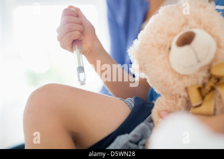 Boy taking insulin injection in leg Stock Photo