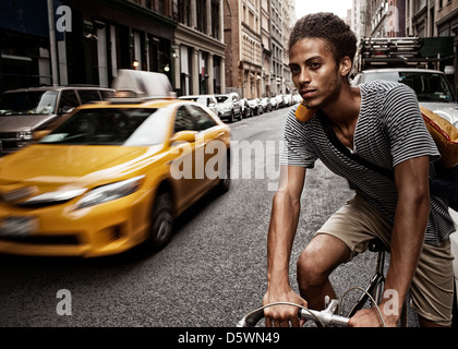 Man riding bicycle on city street Stock Photo