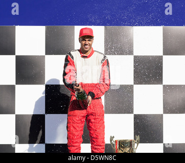 Racer opening champagne at award ceremony Stock Photo