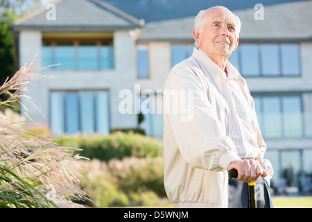 Older man walking with cane outdoors Stock Photo