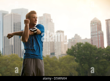 Runner stretching in urban park Stock Photo