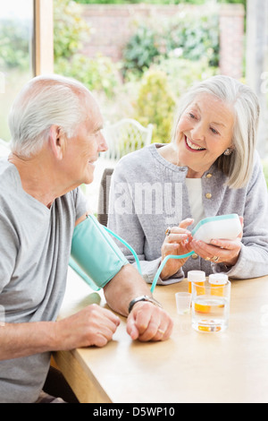 Older woman testing husband's blood pressure Stock Photo