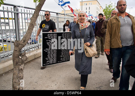 Jerusalem, Israel. 9-Apr-2013. Jews and Arabs march together in a procession carrying plaques bearing the names of the victims of the Deir Yassin Massacre, under tight police protection, to the few remaining structures of the 1948 Arab village invaded and destroyed.     Deir Yassin, a pre-1948 Arab village adjacent to Jerusalem with a population of about 600, was invaded by paramilitaries from the Jewish Irgun and Lehi groups on April 9, 1948 and around 115 villagers were massacred. Credit: Nir Alon/Alamy Live News Stock Photo