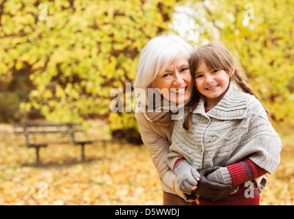 Older woman and granddaughter smiling in park Stock Photo