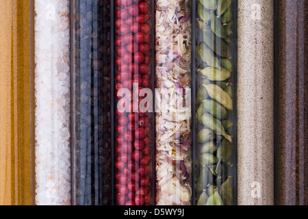 A selection of herbs and spices in glass tubes in the kitchen. Stock Photo
